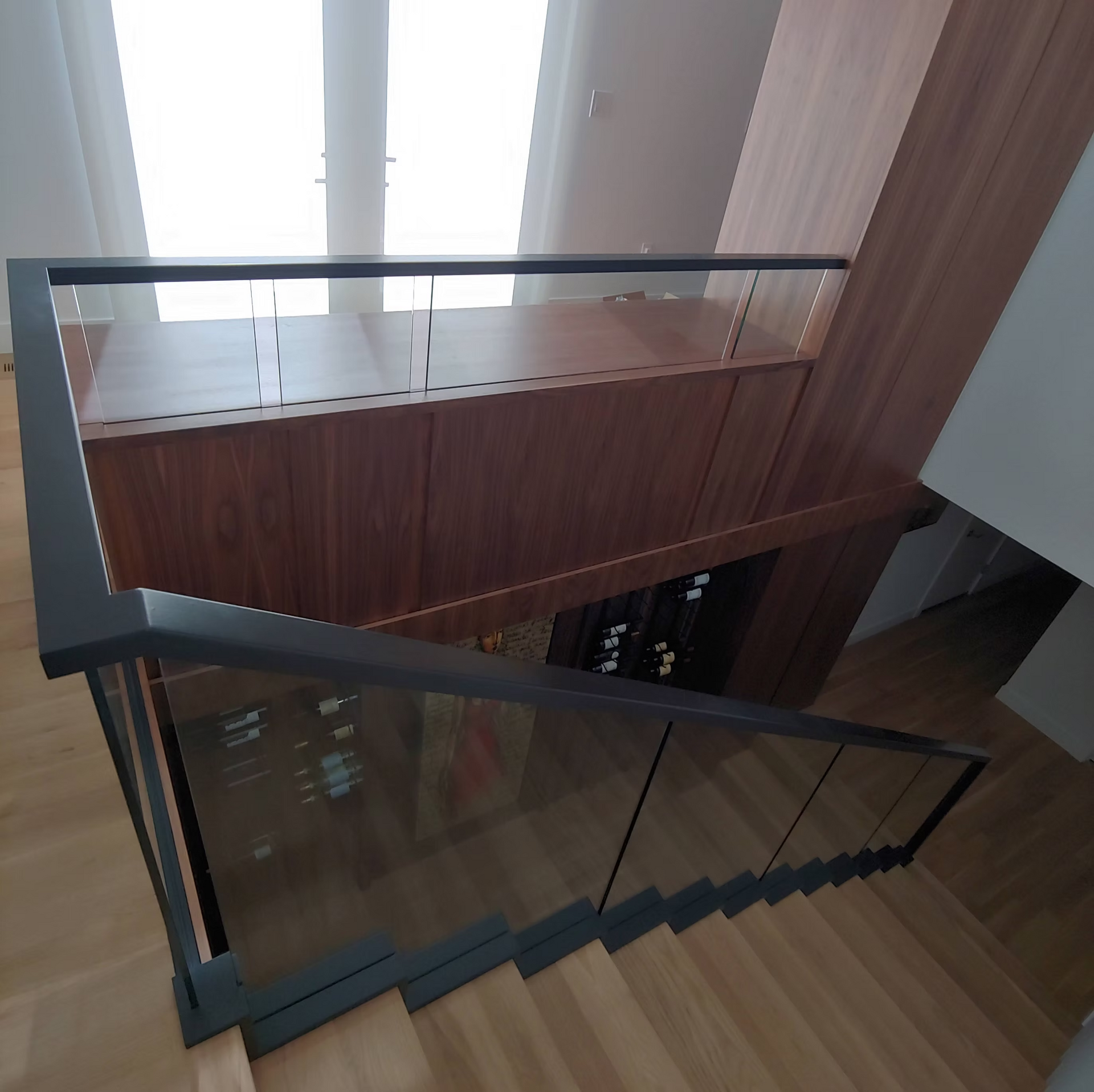 A staircase with a glass railing and wooden steps