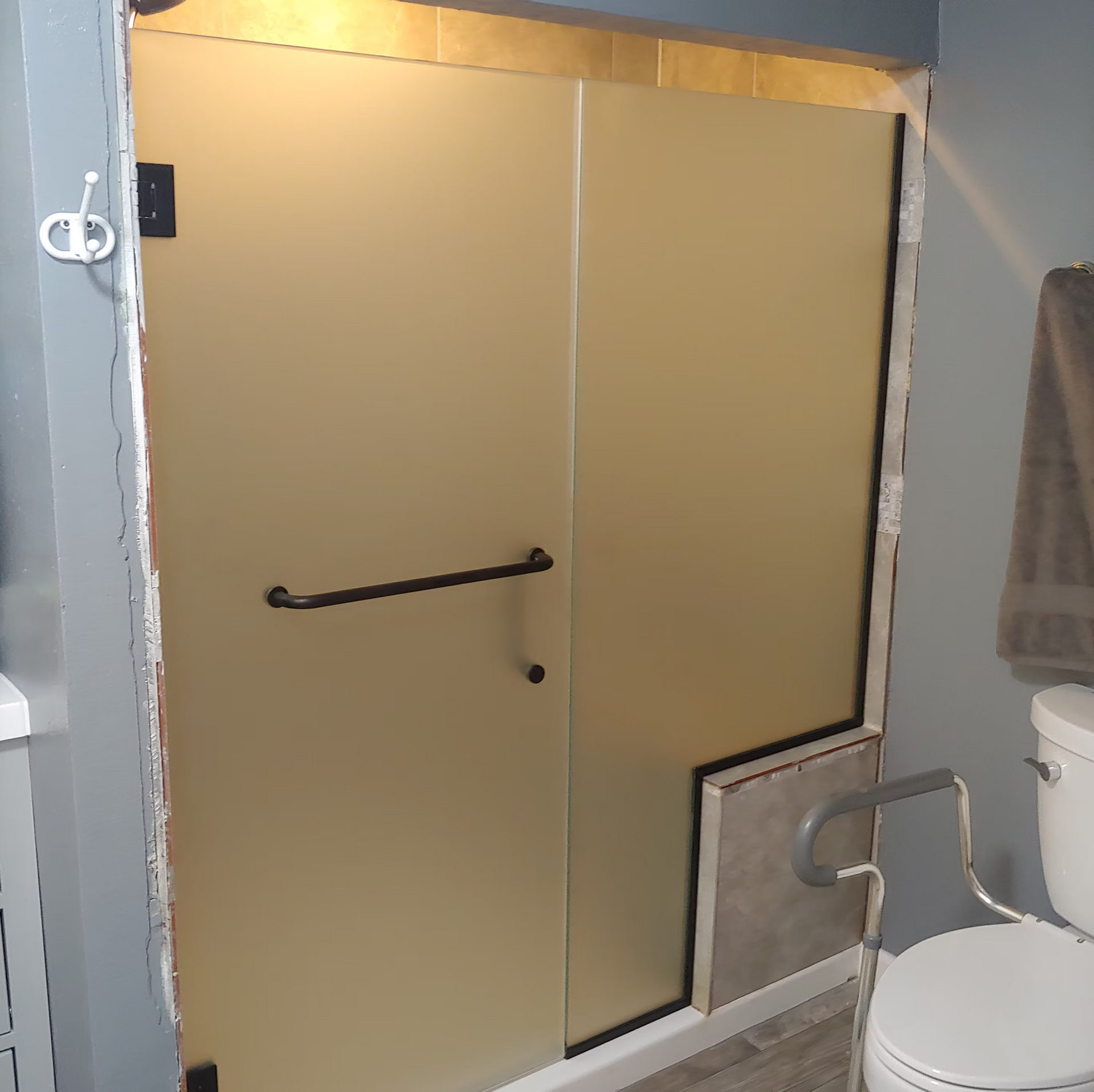 A bathroom with a toilet and a shower with a glass door.