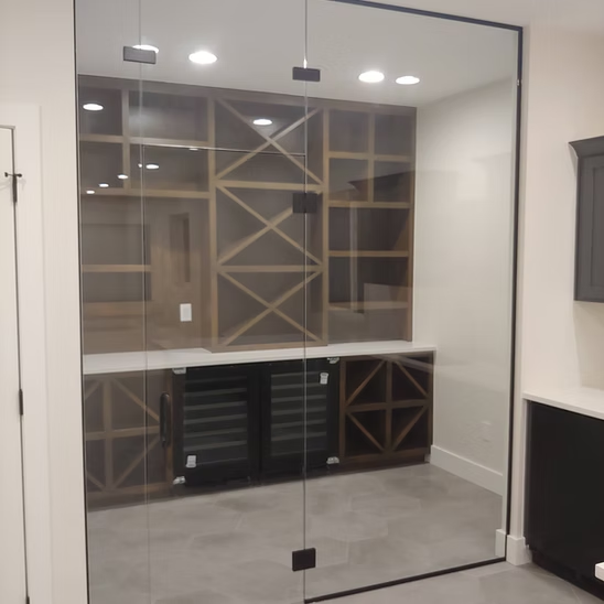 A room with a glass wall and a wine cooler