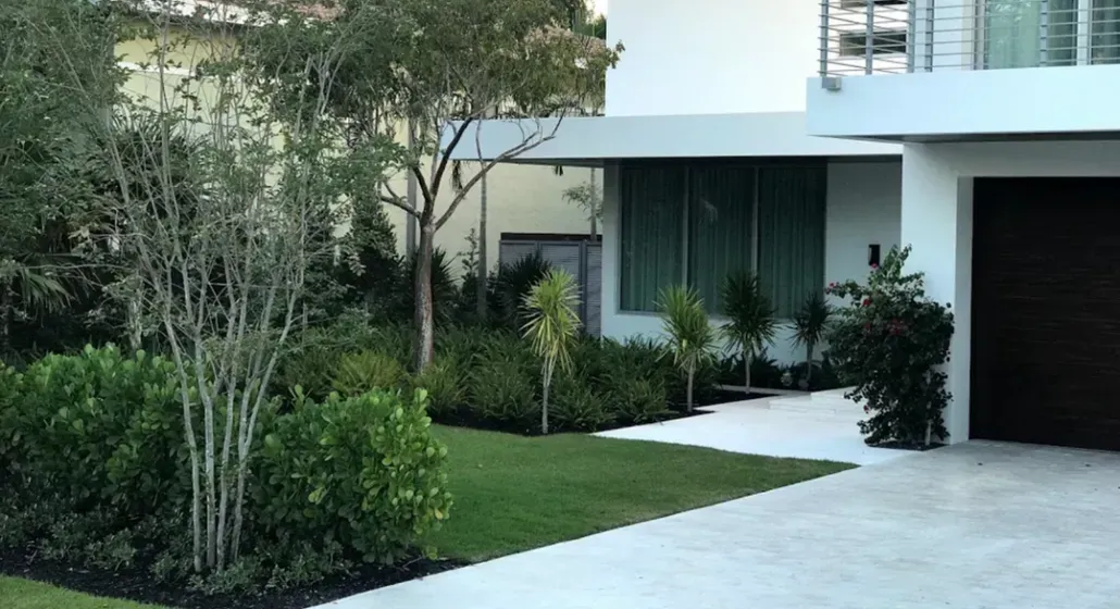 Modern house with green lawn, landscaping, and driveway.