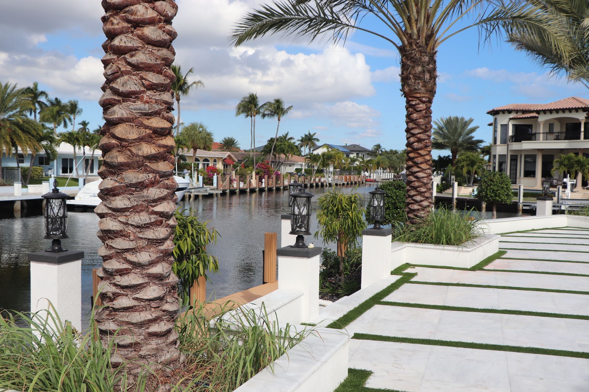 Backyard patio with wooden deck, awning, seating, and green lawn.