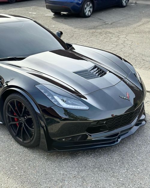 A black sports car is parked on the side of the road.