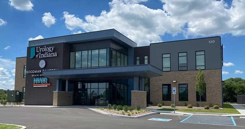 Urology of Indiana building exterior with a blue and grey façade, glass entrance, and accessible parking.