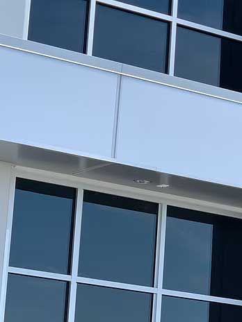 Modern building exterior with windows and white panels.