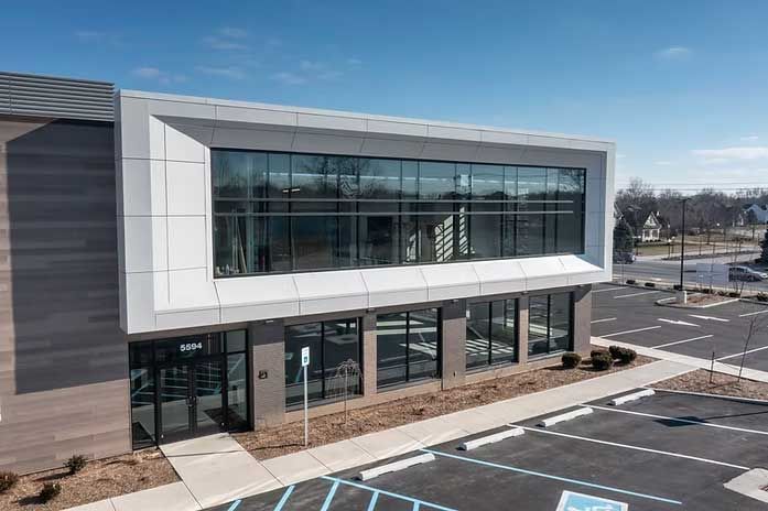 Modern commercial building with large windows and white trim, exterior shot.