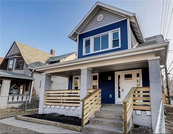 Two-story house with blue siding, gray trim, front porch, and concrete steps.