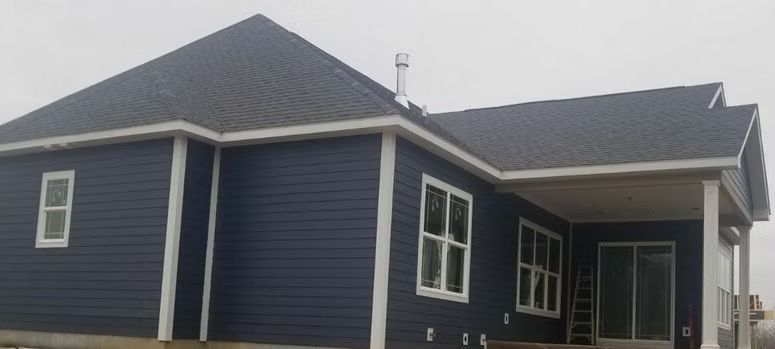 Blue house with white trim, gray roof, and a covered porch.