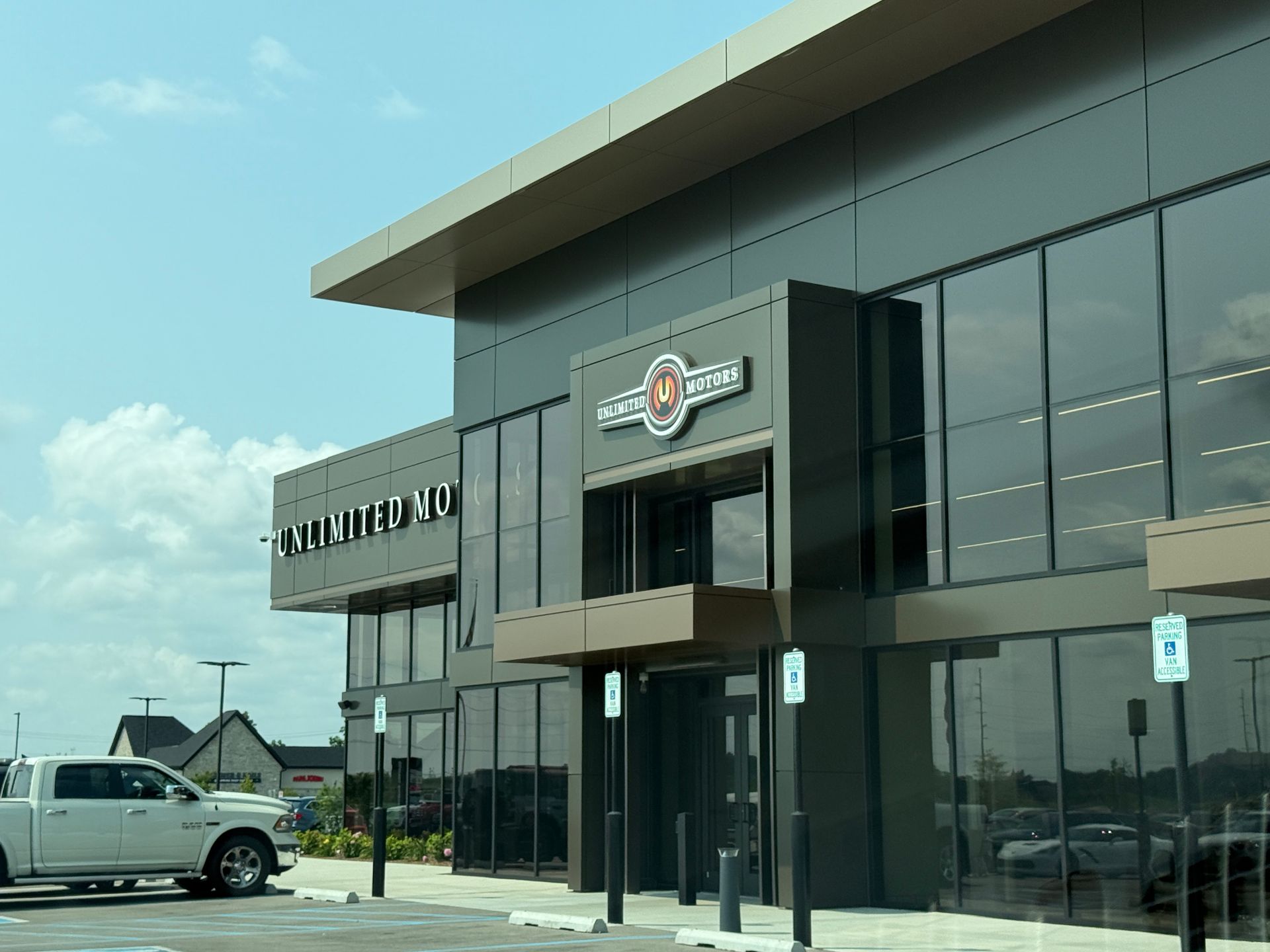 Modern commercial building with large glass windows and a parked white pickup truck outside