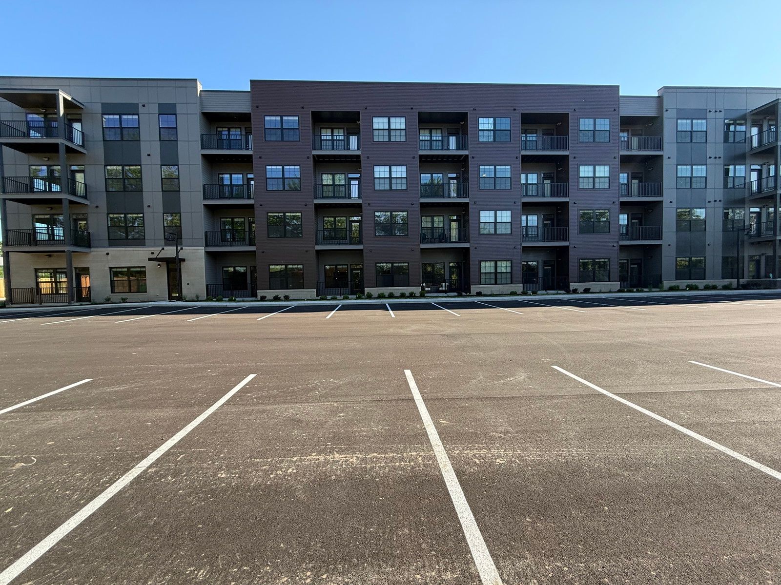 Empty parking lot in front of modern apartment buildings with balconies
