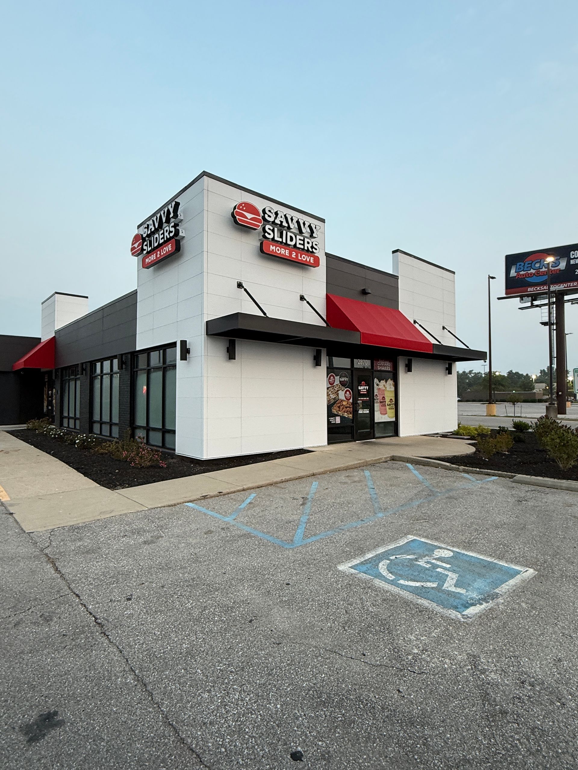 Small fast-food restaurant with red awnings and a handicap parking space in front