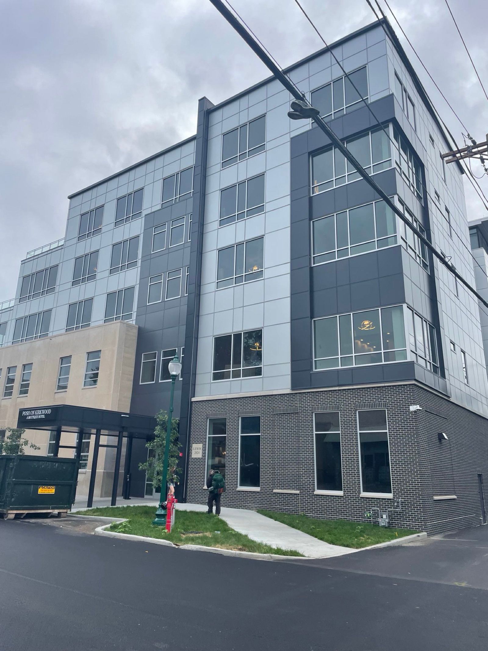 Modern multi-story office building with gray and white facade on a cloudy day