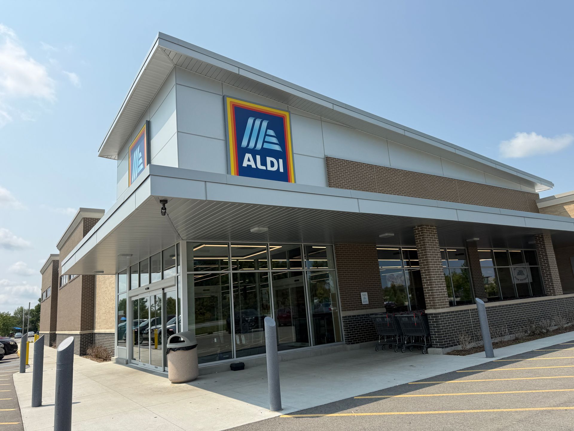 ALDI grocery store exterior with glass entrance and blue logo under a clear sky