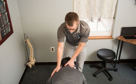 A man is giving a man a massage in a room.