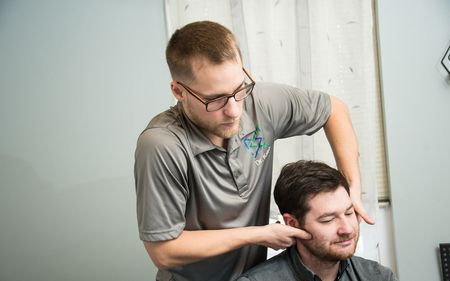 A man is giving a man a massage in a room.