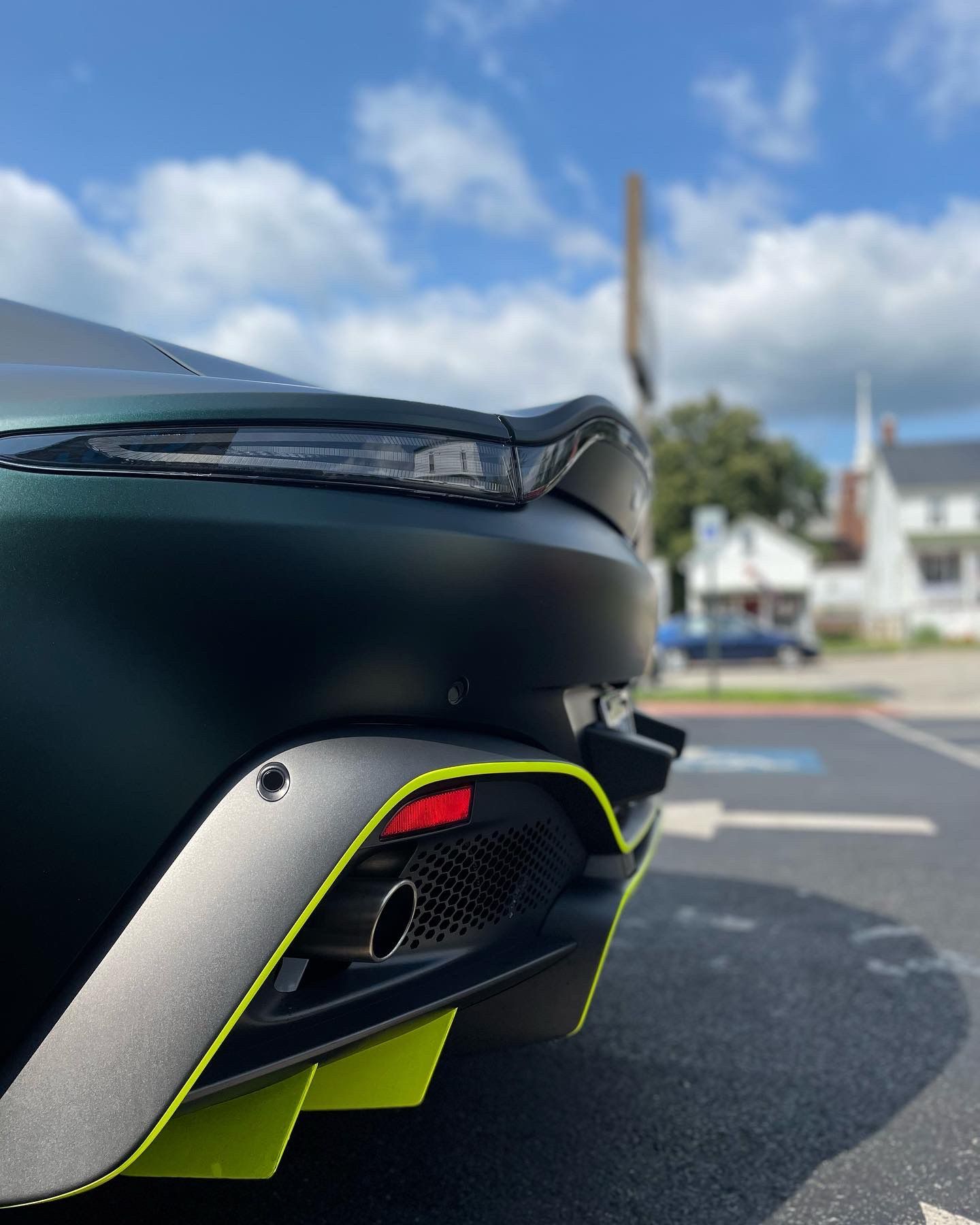 a black car with a yellow stripe on the side is parked on the street