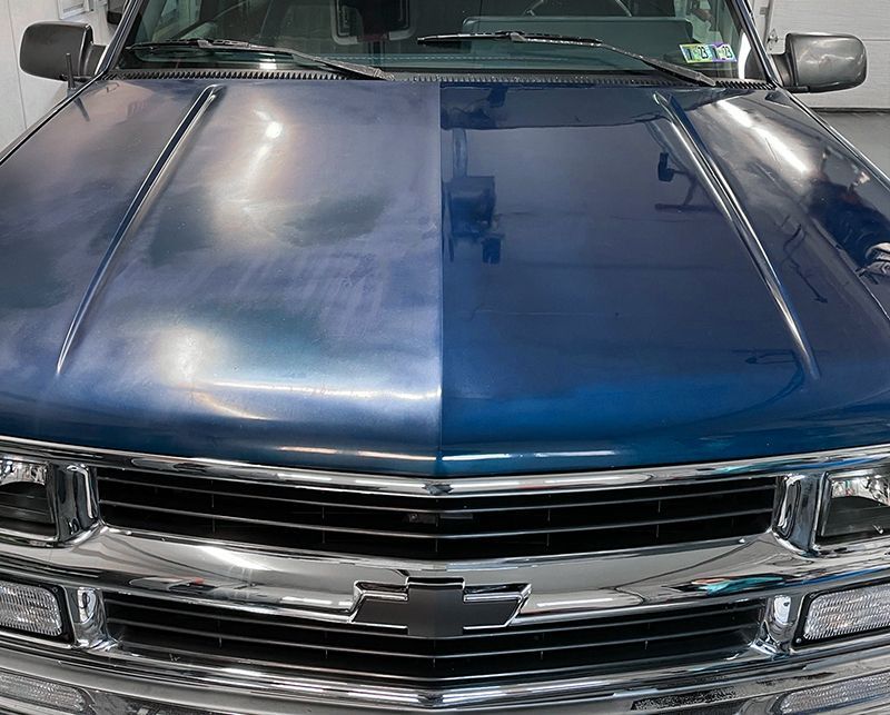 a blue chevrolet truck is parked in a garage
