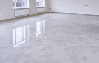 a large empty room with a shiny tiled floor and white walls 