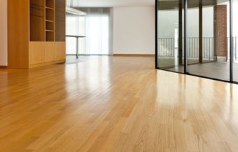 an empty room with a wooden floor and sliding glass doors 