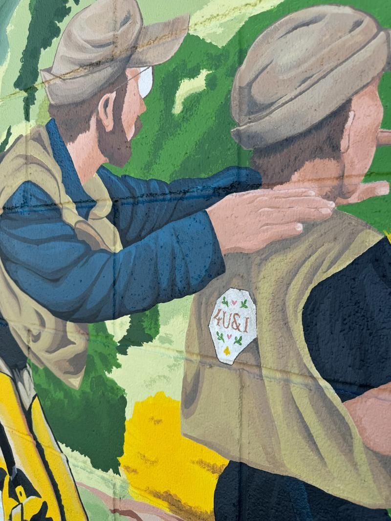 A painting of two men with one wearing a vest that says hi & i