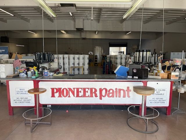 A pioneer paint store with a counter and stools