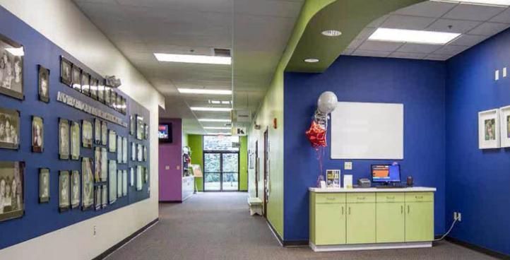 A long hallway with blue walls and green cabinets