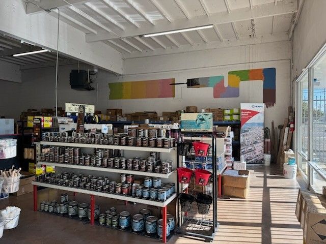 A store filled with shelves filled with cans of paint.