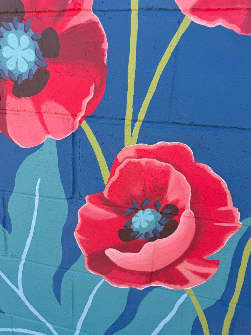 A close up of a painting of red flowers on a blue background