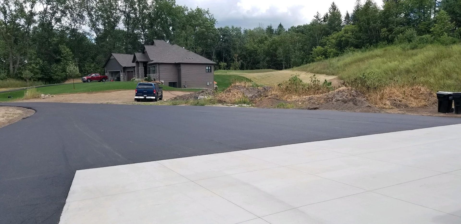A car is parked on the side of a road next to a house.