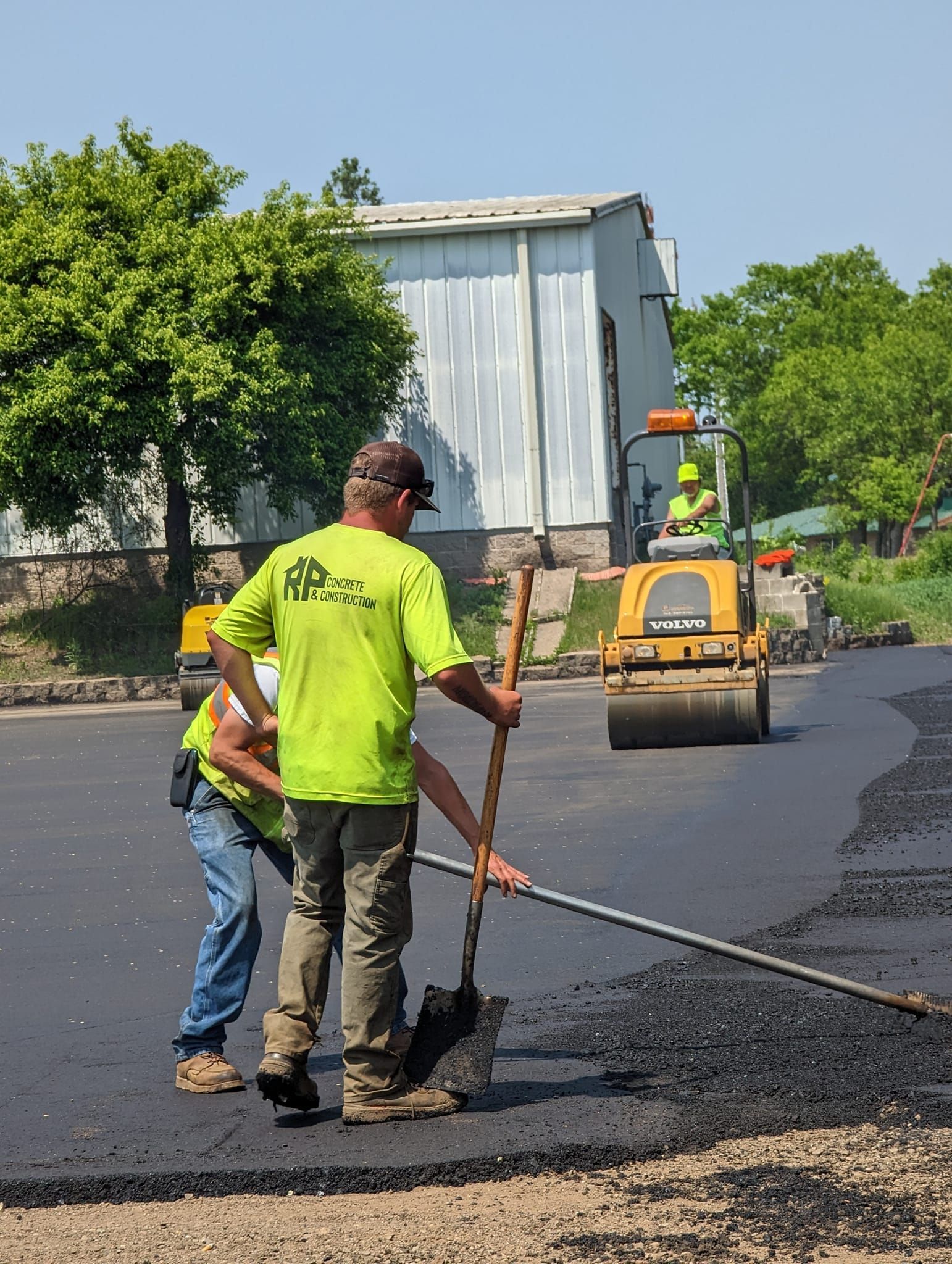 A group of construction workers are working on a road.