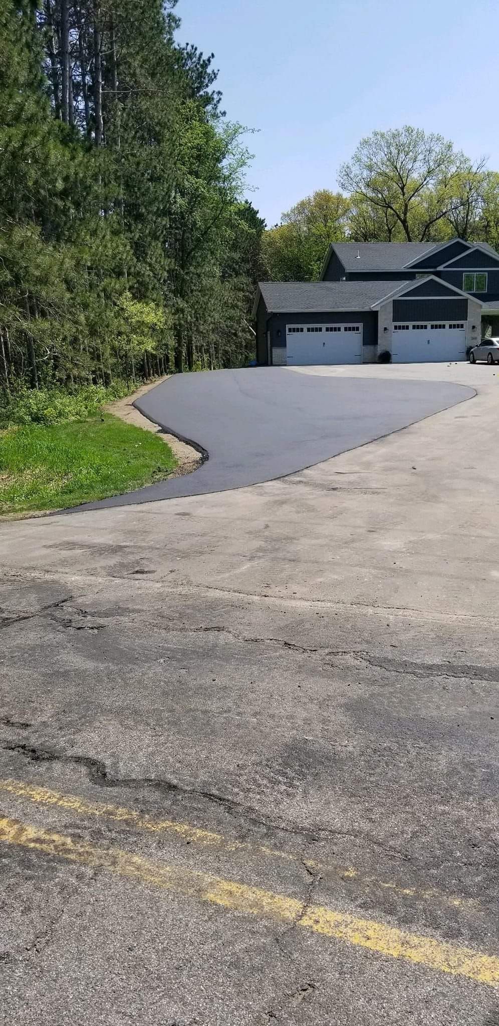 A car is parked in a driveway next to a house.