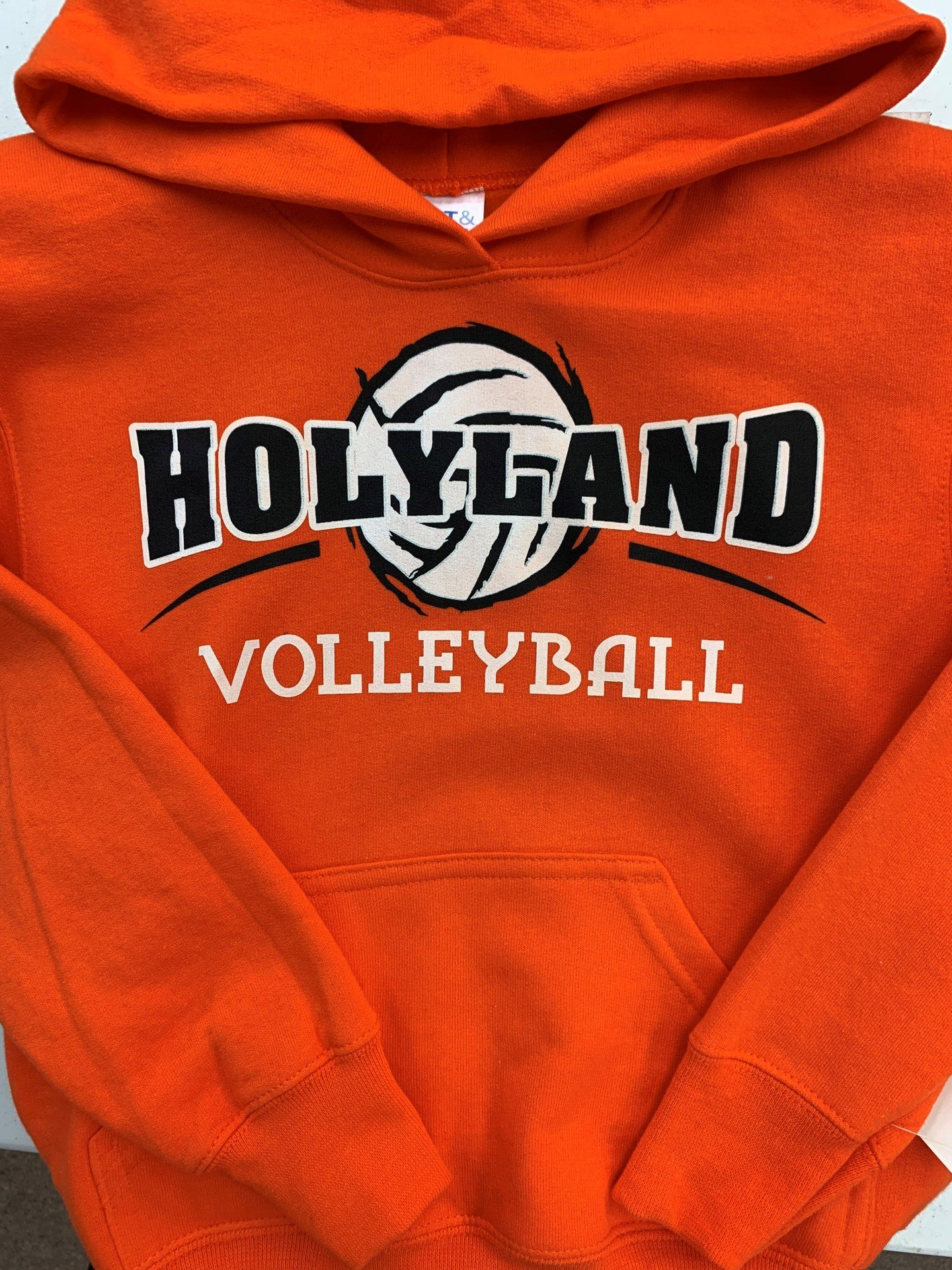 An orange hoodie that says holyland volleyball on it