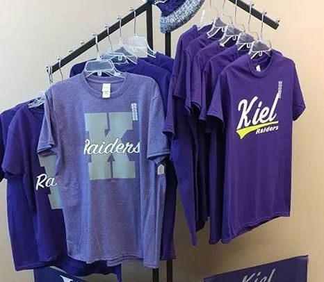 A rack of purple t-shirts hanging on a rack.