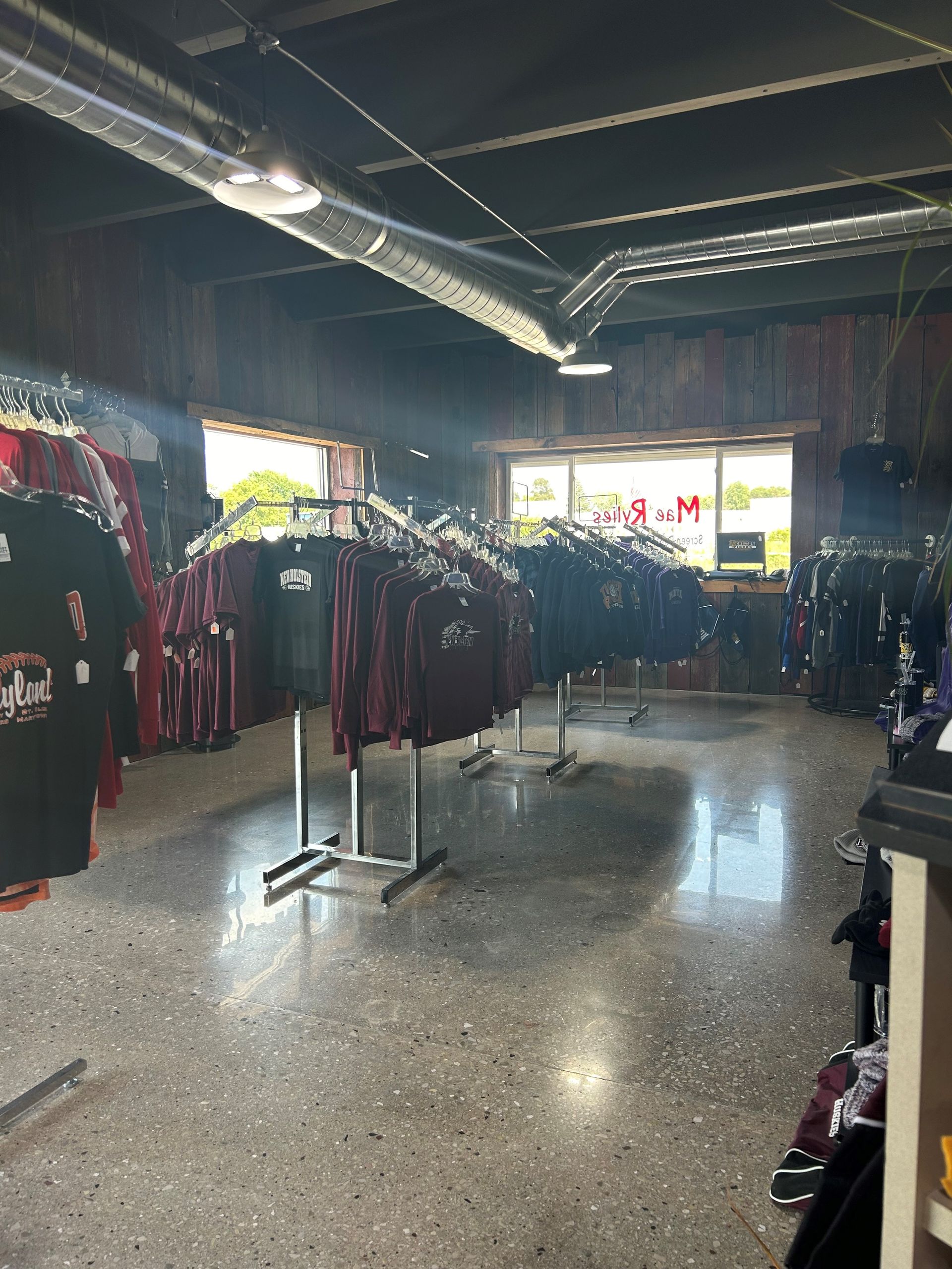 A store filled with lots of shirts hanging on racks.
