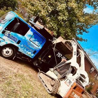 a blue and white truck is parked next to a bulldozer
