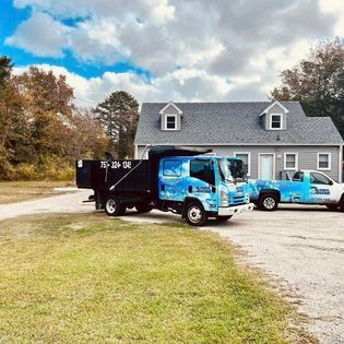 two dump trucks are parked in front of a house