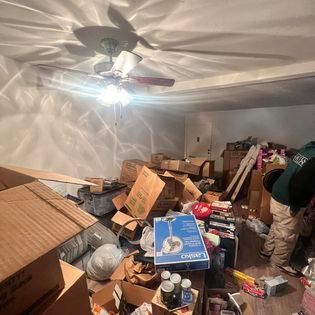 a room filled with boxes and a ceiling fan