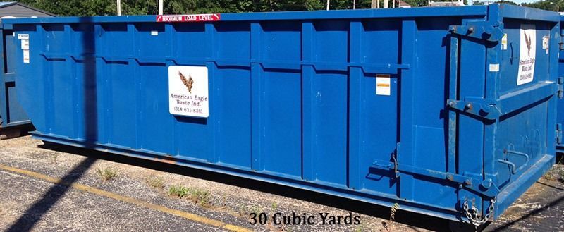 Blue dumpster on asphalt, with a sign indicating it is 30 cubic yards.