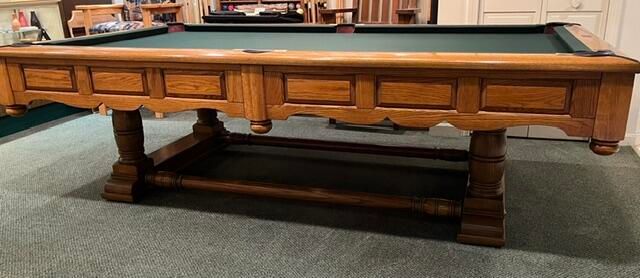 8' Pro Brunswick Prestige Oak
Wooden billiards table with green felt, shown in a room on a carpeted floor.
