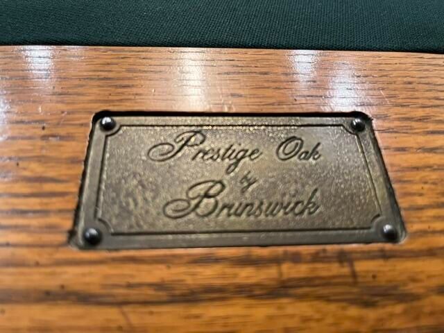 Brass plaque on a wooden surface reading “Prestige Oak Brunswick”