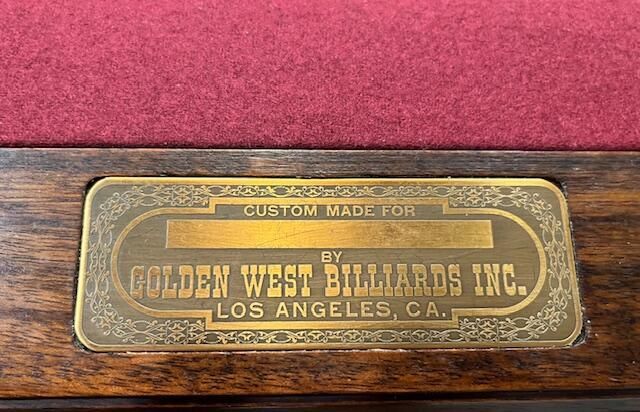 Wooden pool table with green felt, in a room