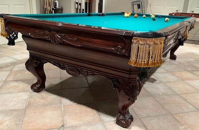 A pool table is sitting on the floor in a room.