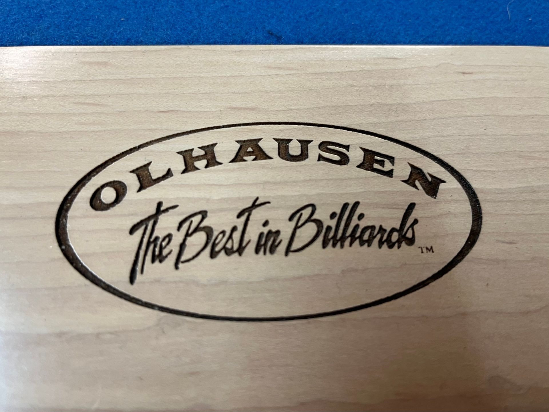 Pool table with blue felt, light colored wood frame, and hardwood floor.