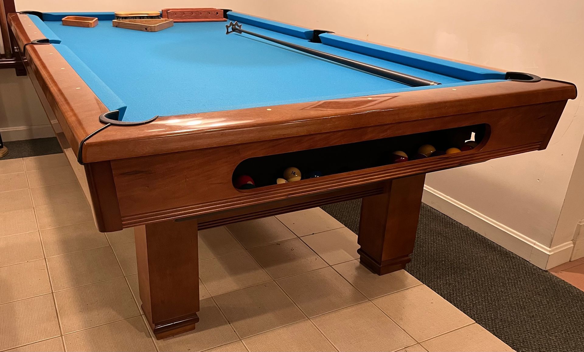 A pool table is sitting on a carpeted floor in a room.