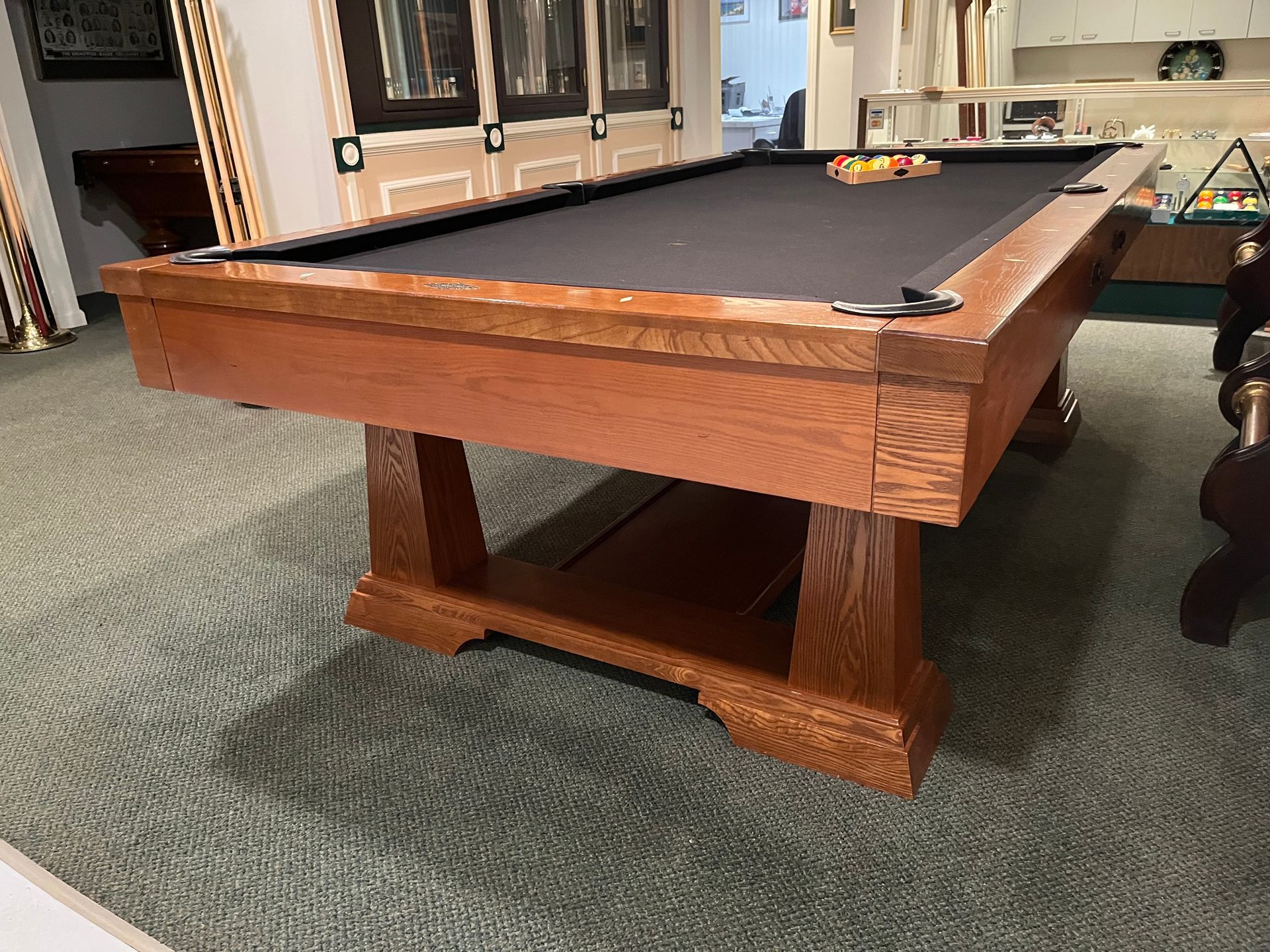 A pool table is sitting on a carpeted floor in a room.