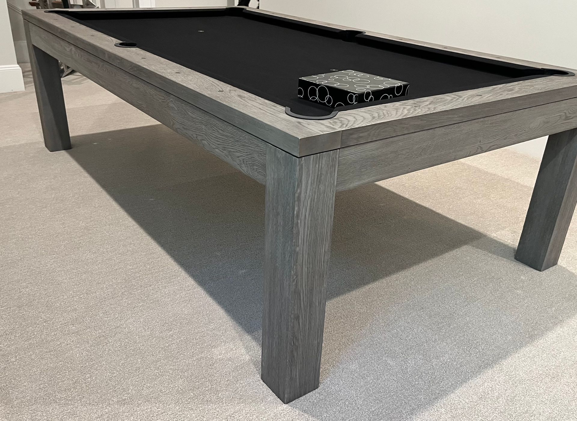 An 8' Olhausen Drake pool table is sitting on a tiled floor in a room.