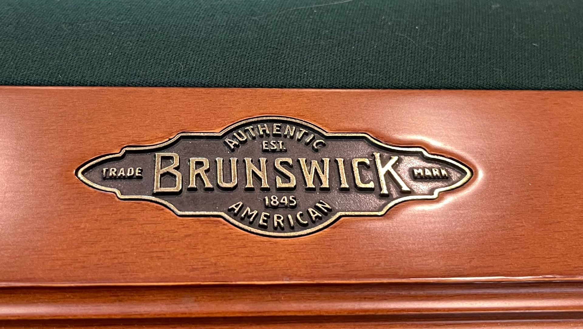 Brunswick wooden sign emblem with gold lettering on a brown surface