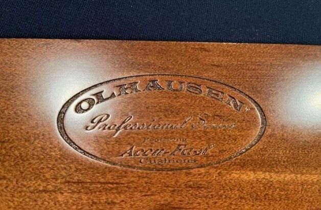 Oval wooden Olhausen pool table logo.