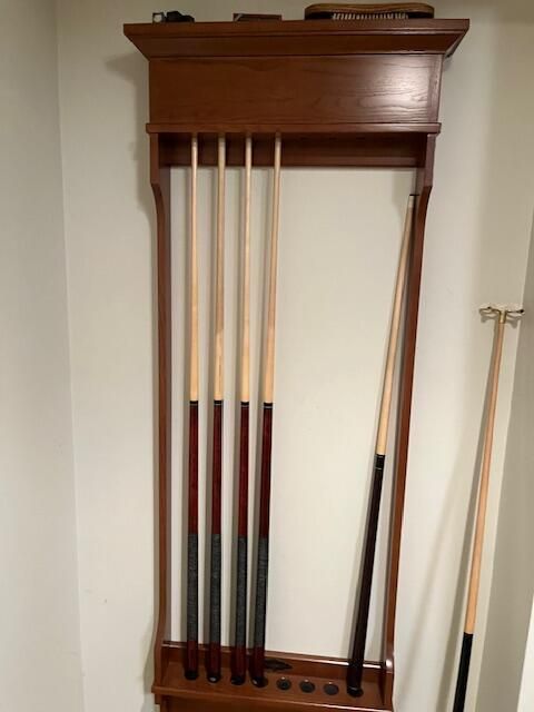 A rack of pool cues hanging on a wall