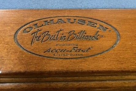 Olhausen pool table brand name engraved on wood