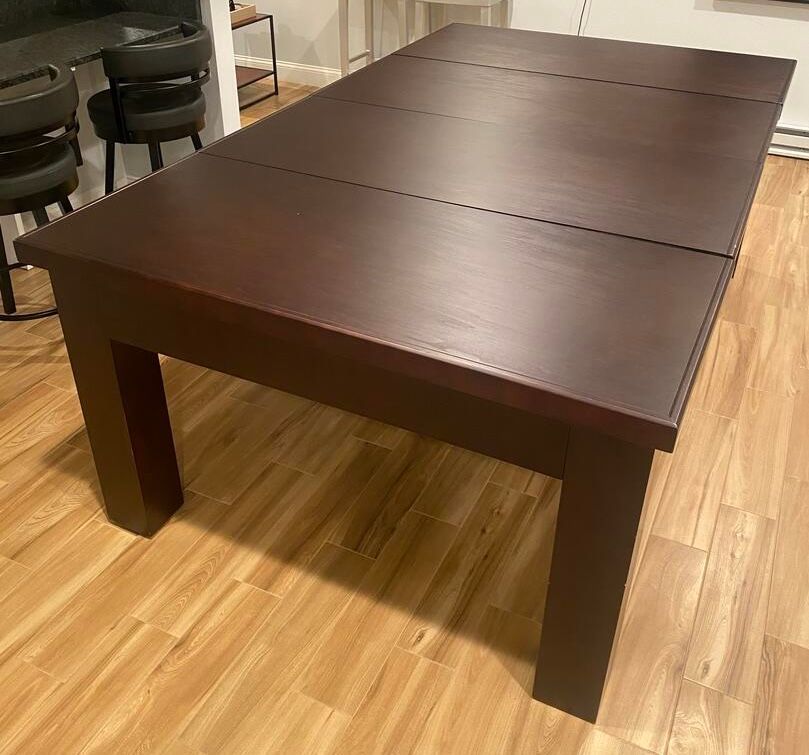 Dark brown wooden dining table on a light-colored wood floor.
